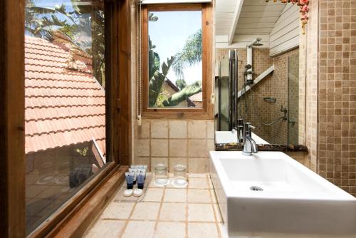 a bathroom with a sink and a window at Vitrage Holiday Village and Spa in Bet Hillel