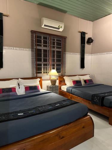 a bedroom with two beds and a window at Chang's Hideaway homestay ConDao in Con Dao