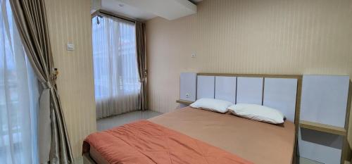ein Schlafzimmer mit einem Bett mit zwei Kissen und einem Fenster in der Unterkunft Apartemen Green Park Yogyakarta in Seturan