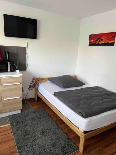 1 dormitorio con 1 cama y TV en la pared en Apartment (2) am Stuttgarter Flughafen / Messe, en Leinfelden-Echterdingen