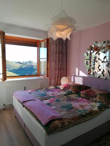 a bedroom with a large bed with a large window at Summer Wine in Leutschach