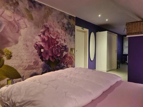 een slaapkamer met een groot bed met een bloemenmuur bij Hemelse Helderheid in Maasmechelen