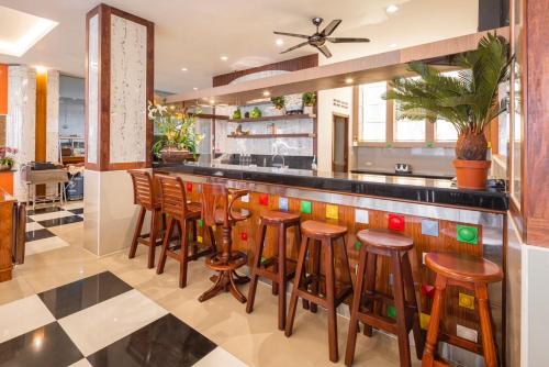 a bar in a restaurant with wooden stools at Sunshine Patong in Patong Beach
