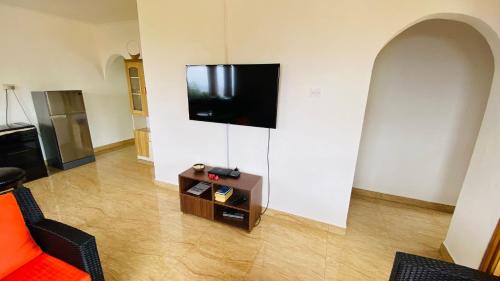 a living room with a flat screen tv on a wall at Josies Cottage in Beau Vallon