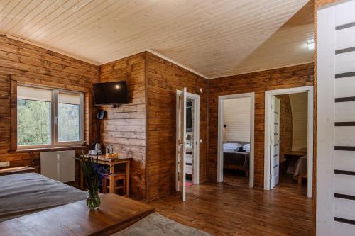 a room with wooden walls and a bed and a desk at Рибничанка in Skhidnitsa