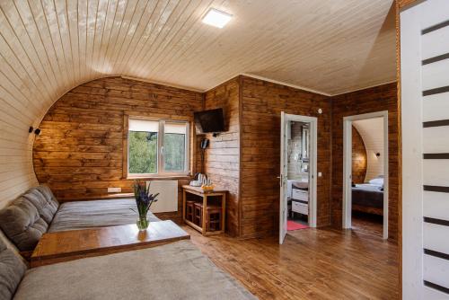 a living room with a couch in a room with wooden walls at Рибничанка in Skhidnitsa