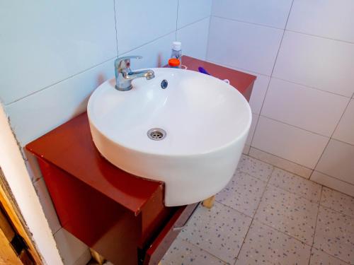 ein Bad mit einem weißen Waschbecken im Zimmer in der Unterkunft Arusha Jua home in Arusha