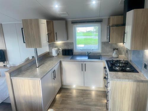 a kitchen with white cabinets and a stove top oven at Charming 2-Bed Chalet in Tuxford in Tuxford