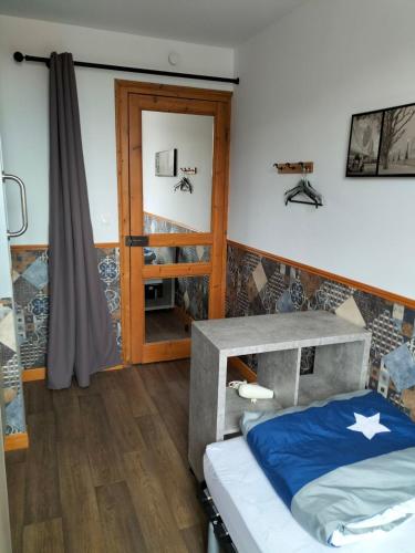 - une chambre avec un lit et une porte en bois dans l'établissement LAETITIA ET CLAUDE, à Lille