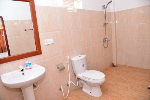 Un baño con inodoro, lavabo y ducha. en Athula Hikka beach Guesthouse, en Hikkaduwa