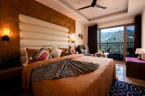 a bedroom with a large bed with a large window at PerfectStayz Mall Road Mussoorie in Mussoorie