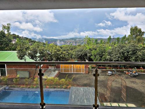 a view of a swimming pool from a balcony at Malibu Villa by Hill Staytion in Panchgani