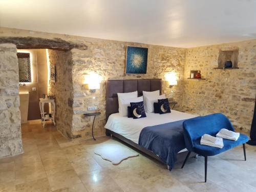 1 dormitorio con 1 cama grande y paredes de piedra en Chambre d'hôte avec SPA privatif domaine les nuits envôutées - Gard, en Vézénobres
