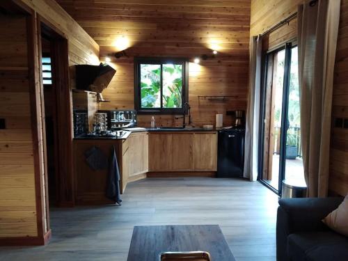 uma cozinha com paredes de madeira e uma mesa num quarto em Ti Natte em Saint-Philippe