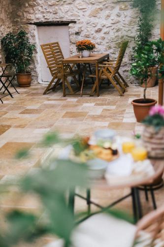 a table and chairs on a patio with plants at Limeria studios & maisonettes in Parga