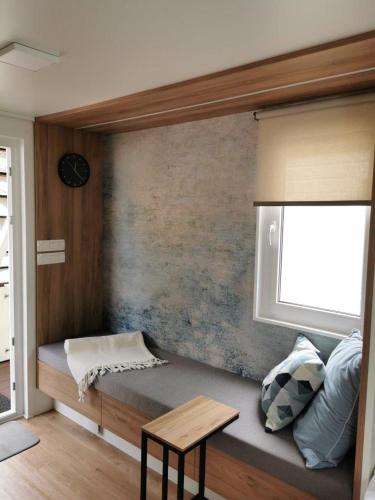 a small bed in a room with a window at Marinavita - a floating house in Portorož