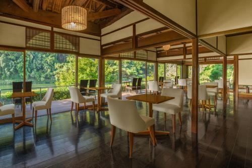 a restaurant with tables and chairs and large windows at Suiran, a Luxury Collection Hotel, Kyoto in Kyoto