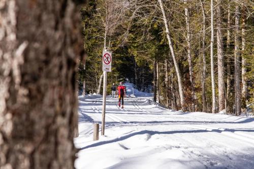 a person is cross country skiing down a snow covered road at Hotel Berlin Tegernsee in Rottach-Egern