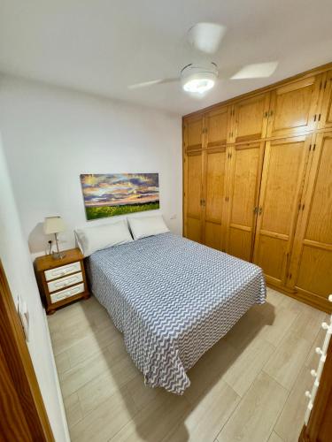 ein Schlafzimmer mit einem Bett und Holzschränken in der Unterkunft CASA EN PLENO CENTRO DE LA CALA DE MIJAS by Holidays2Rent in La Cala de Mijas