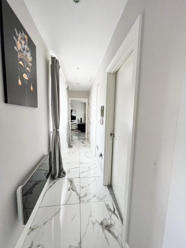a hallway with marble flooring and a mirror at 2 Double Bedroom Apartment in Edgware, London in Edgware