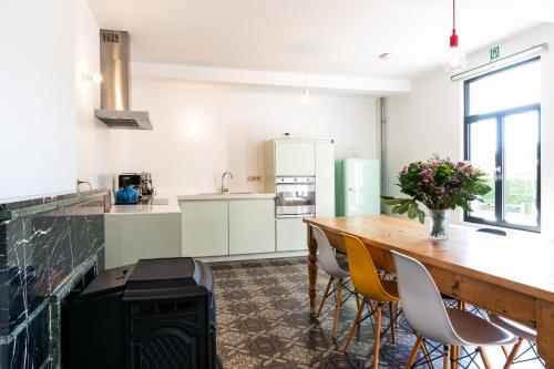 a kitchen with a table and chairs and a stove at Hullehuis in Lotenhulle