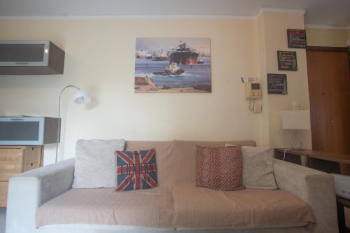 雅典的住宿－Athens Riviera Vibes，客厅的沙发,墙上有绘画作品
