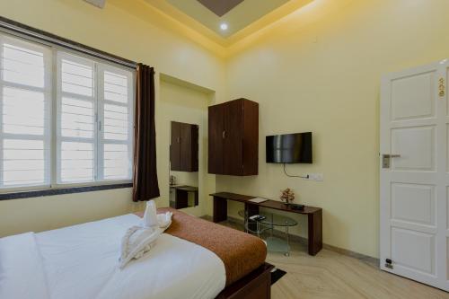 a bedroom with a bed and a window and a desk at Silver Galaxy Resort in Panchgani