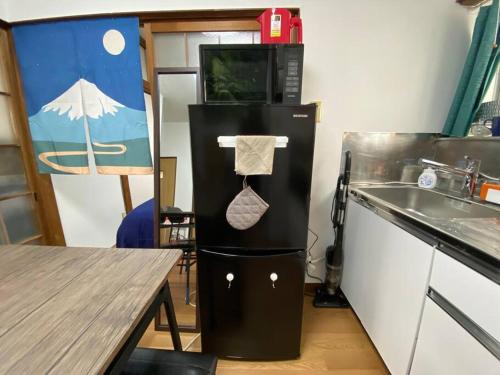 a kitchen with a refrigerator and a sink and a table at Good aces to Shibuya/2mins walk sta/Max12ppl/1flor in Tokyo