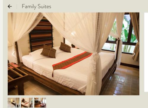 a bedroom with two beds with white sheets and curtains at Baan Orapin in Chiang Mai
