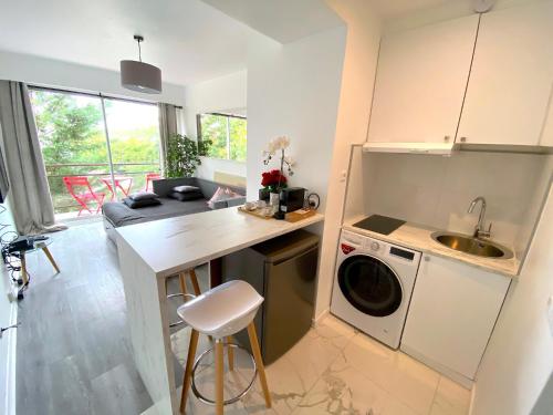 une cuisine avec un évier et une machine à laver dans l'établissement le studio Molitor, à Boulogne-Billancourt