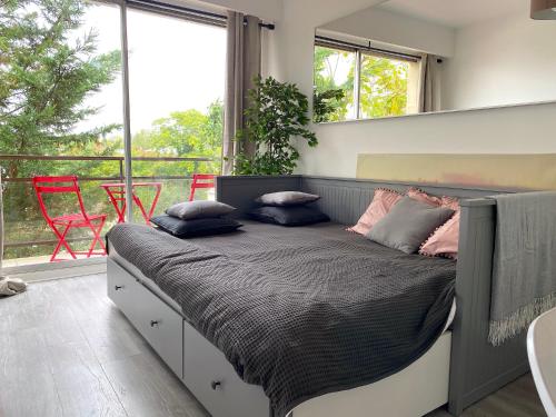 une chambre avec un grand lit avec des oreillers dessus dans l'établissement le studio Molitor, à Boulogne-Billancourt