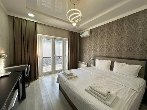 um quarto com uma cama grande com duas toalhas em VIP Hotel em Tashkent