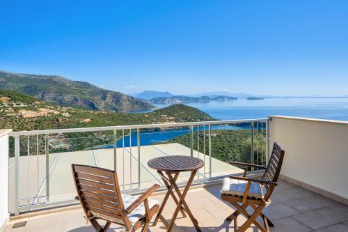a balcony with a table and chairs and the ocean at Alfresco Villas in Sivota
