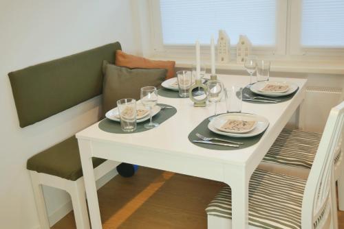 una mesa blanca con platos y vasos. en Ferienhaus Anni & Fritz en Goslar