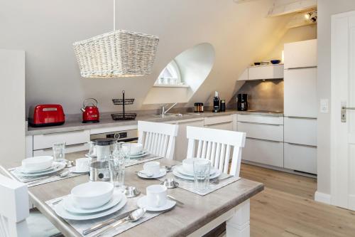 a kitchen with a dining table with white cabinets at Moin Moin in List