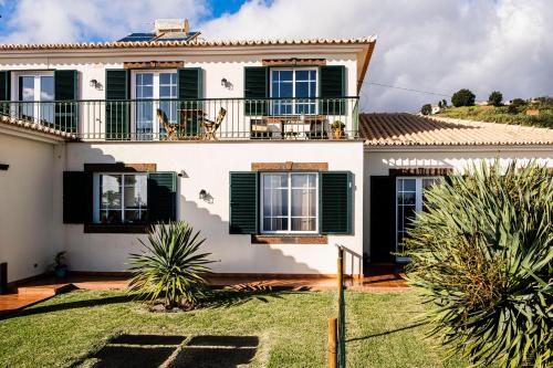 a large white house with green shutters at Namastê House I in Relógio do Poiso