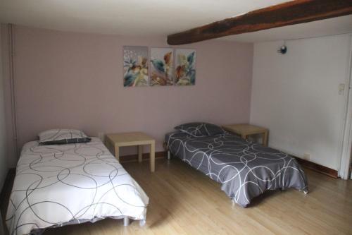 a bedroom with two beds and a painting on the wall at La maison de la Place in Chooz