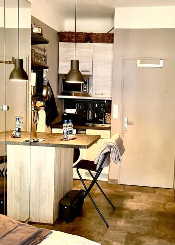 a kitchen with a counter and a table with a chair at Traum in der Grazer Innenstadt - Klein aber Fein! in Graz