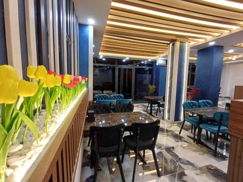 White Palace Hotel في إسطنبول: مطعم على الحائط طاولات وكراسي وزهور