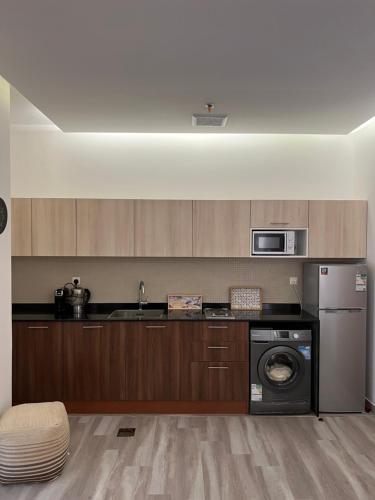 a kitchen with a washing machine and a microwave at Your home 2 in Jeddah