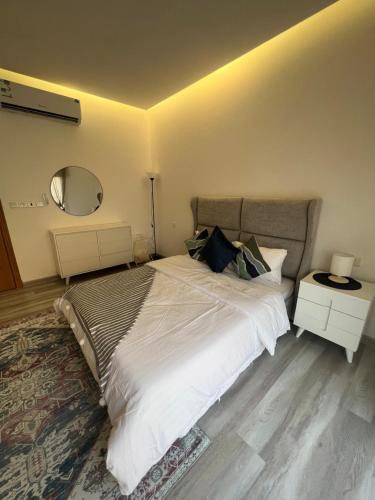 1 dormitorio con 1 cama blanca grande y espejo en Your home 2 en Yeda