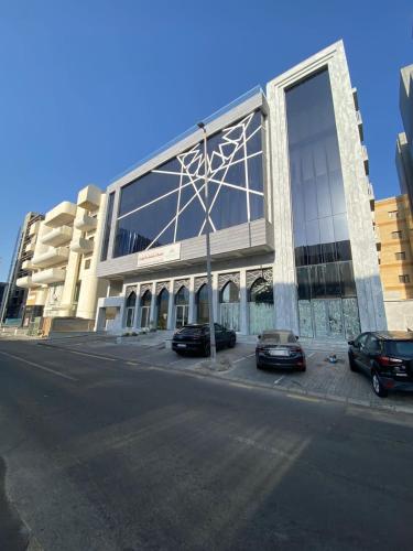 a large building with two cars parked in front of it at Your home 2 in Jeddah
