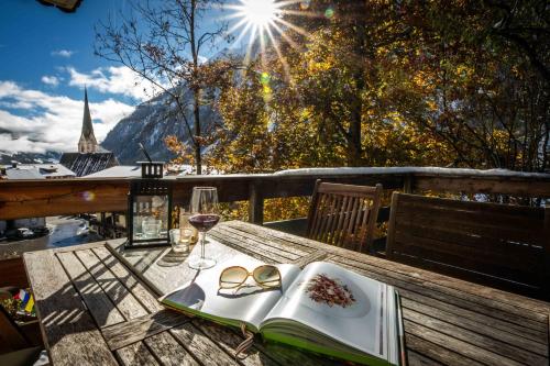 una mesa con un libro y una copa de vino en Alpinside Appartements, en Heiligenblut