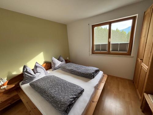 two beds in a room with a window at Haus Widauer in Breitenbach am Inn
