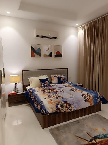 a bedroom with a bed with a blue comforter at Sunsetserenade in Ţāqah