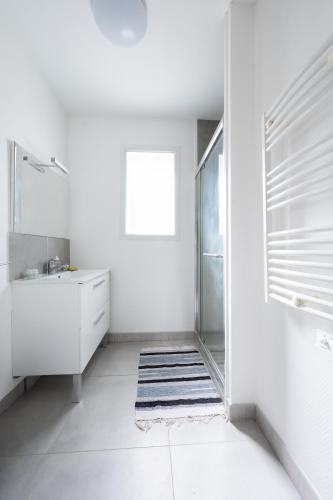 une salle de bain avec une douche, un lavabo et un miroir dans l'établissement La Tulipe Maison à deux pas de la mer, à Le Port-des-Barques