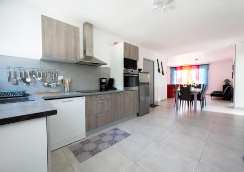 a kitchen with stainless steel appliances and a dining room at La Tulipe Maison à deux pas de la mer in Le Port-des-Barques