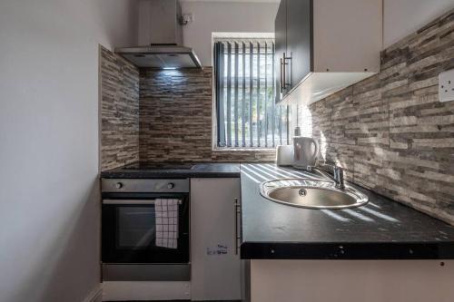 uma cozinha com um lavatório e um fogão em Chic Studio Living: Suite 6 em Parkside