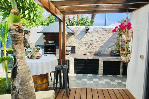 een patio met een tafel en een grill bij Villa Terol, à proximité de l’océan in Saint-Paul