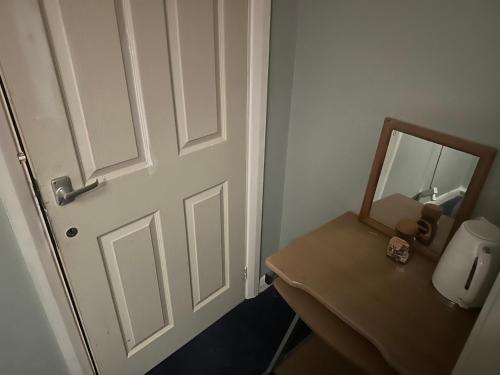 a bathroom with a door and a sink and a mirror at 1 bedroom in 3bed house in Bristol